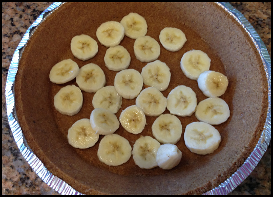 Cut the bananas into thin slices and line the bottom of the graham pie crust.